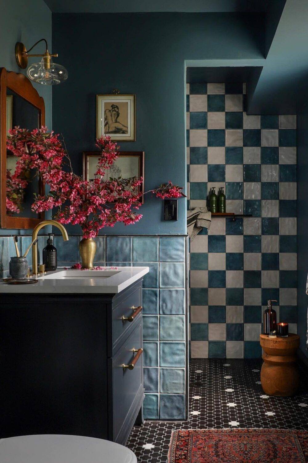 This chic bathroom features blue and white handmade-look tile in a checkerboard and black with white cross-shaped tile floor.