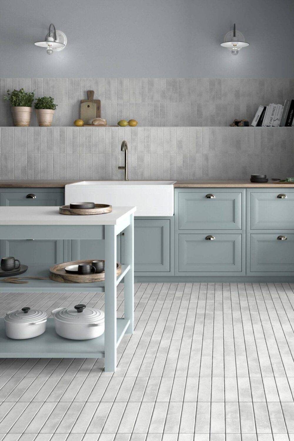 This bright and cheery kitchen features white handmade-look subway tile floor and wall tile and blue cabinets.