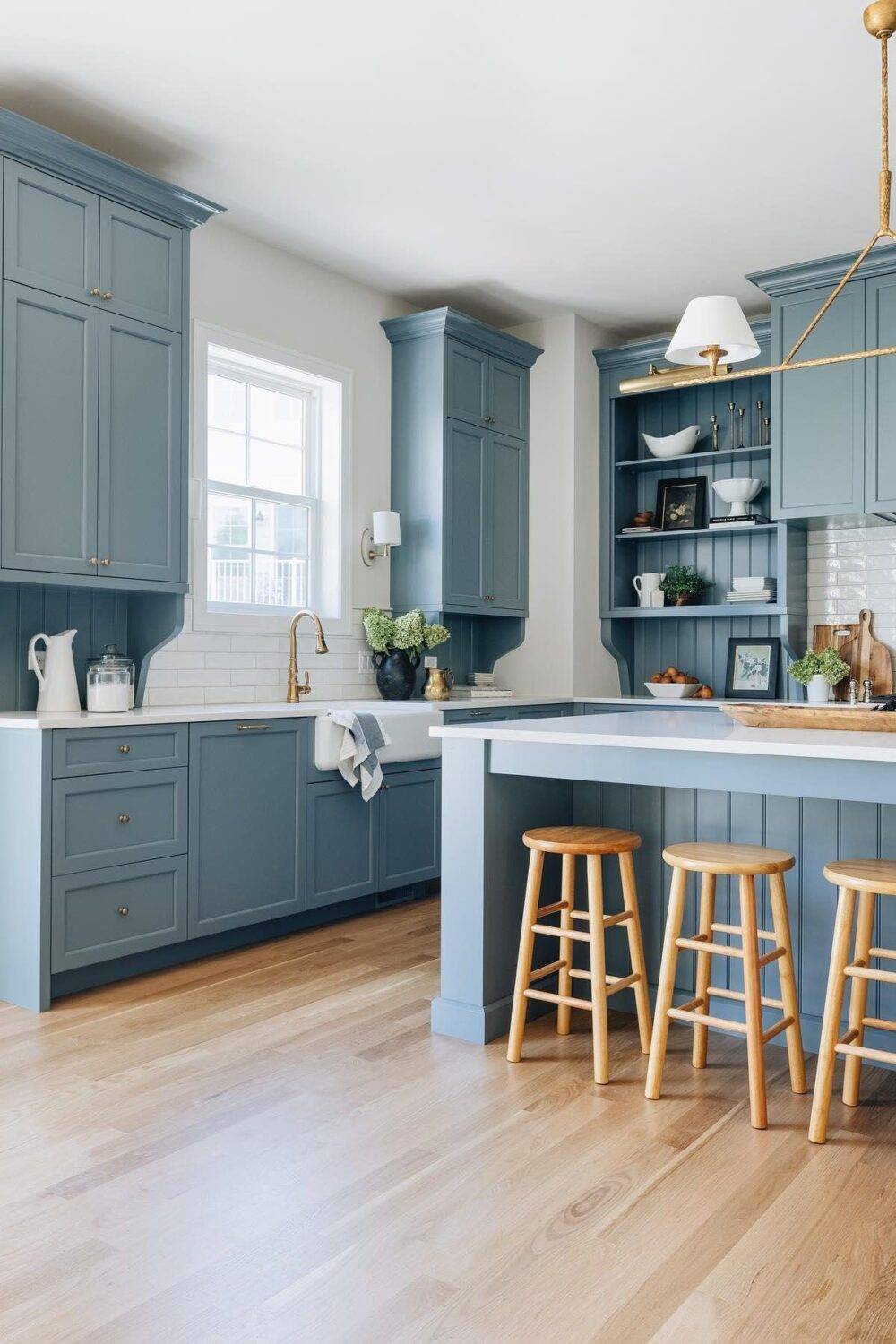 This bright and open kitchen features a white subway tile backsplash and blue cabinets.