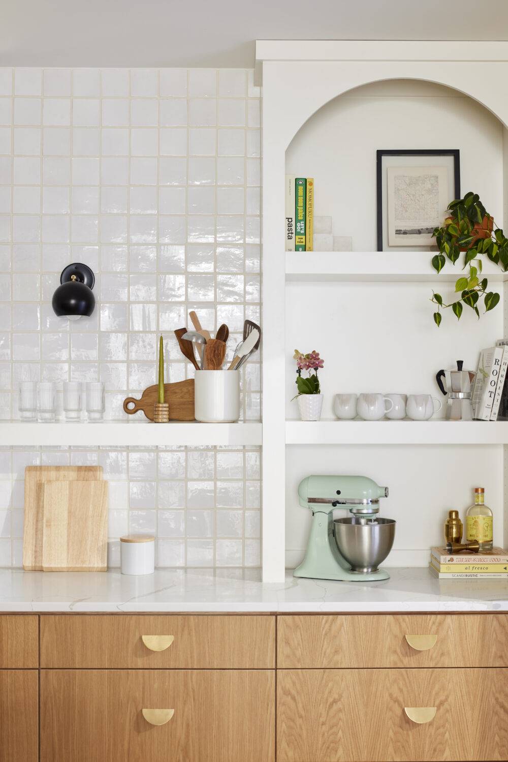 This bright and charming kitchen features white Zellige tile backsplash and open white shelves.