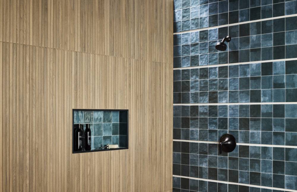 A stylish shower featuring fluted wood-look tile and blue handmade-look tile.