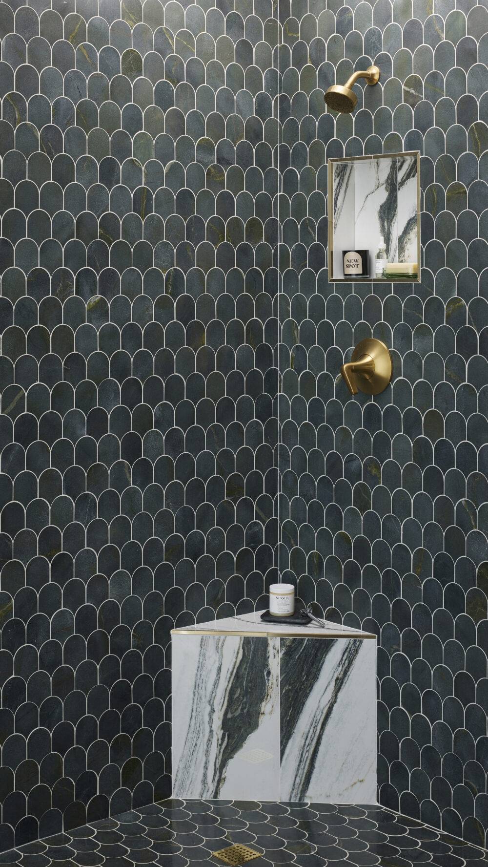 This chic shower features scalloped green marble tile and a marble-look tile with dramatic green veining and gold trim.