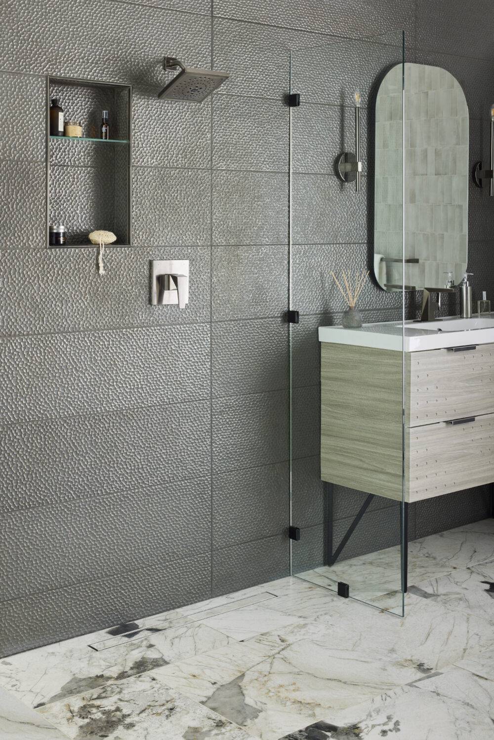This chic industrial bathroom features a steel-look porcelain tile wall and marble-look tile floor.