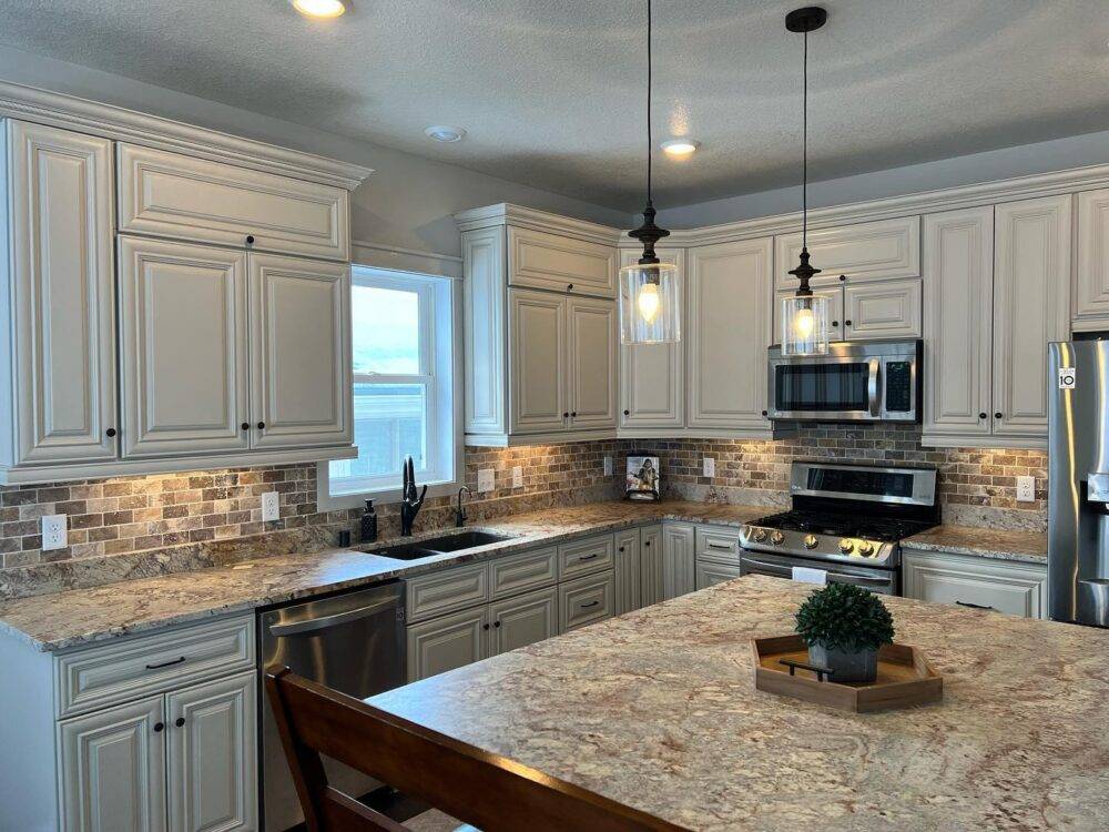 This transitional kitchen features a brown and grey travertine tile backsplash.